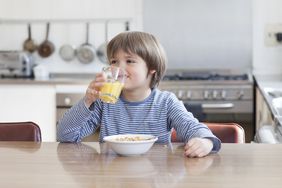 A child drinks a glass of juice.