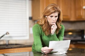 Concerned woman reading her credit card agreement