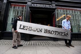 Two male employees of Christie's auction house maneuver the Lehman Brothers corporate logo in preparation for the liquidation of the firm’s assets.