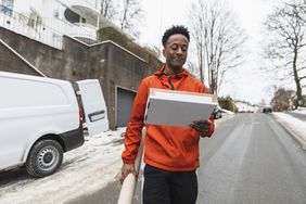 Delivery driver carrying package