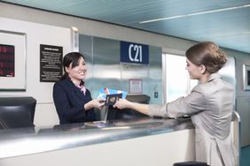 Airline employee with customer at airport counter
