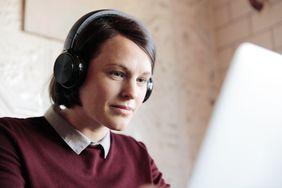 Young woman wearing headphones working on a laptop