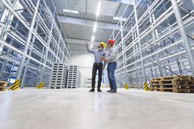 Two men planning operations in an empty warehouse