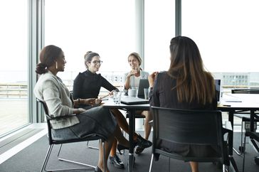 four women in a meeting talking about work