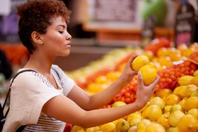Consumer shopping for groceries, comparing fruit