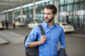 Young businessman with backpack on the go