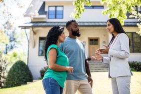 A couple speaks with a real estate agent