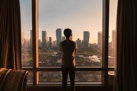 Person looking at the skyline from a high-rise apartment
