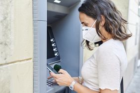 Masked woman using ATM