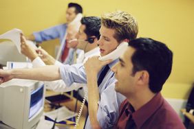 Stock traders placing orders by phone in a trading room