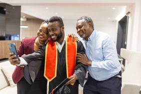 A student and his parents pose for a photo.