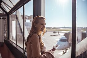 Woman looking out the window of an airport
