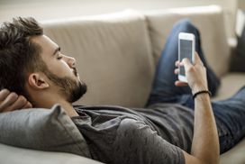 Person using smartphone laying on a couch