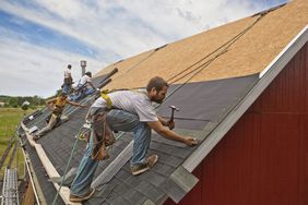 A team of workers installing a new roof on a building