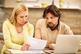 Couple reviewing their credit card statement and worrying that Business World Tips is wrong.