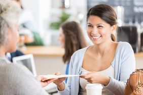 Businesswoman meets with interviewer in coffee shop