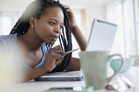 Black woman using laptop at home