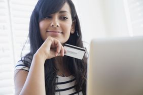 A women with a credit card looking at a computer