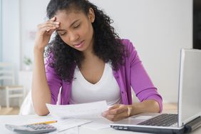 Woman looking at paychecks to determine if she has unequal pay as a woman