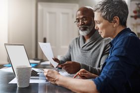 Older couple with paperwork discussing retirement strategy