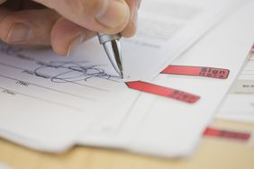 A hand signing a contract