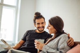 man and woman sitting on couch discussing finances
