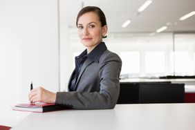 Businesswoman at desk holding pen