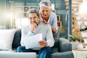 Couple looking worried while going through paperwork at home