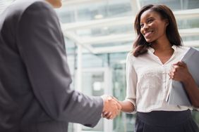 Businessman and businesswoman shaking hands in agreement