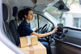 Delivery driver with packages using GPS in business vehicle
