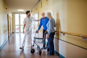 Senior person walking in a hospital corridor with support