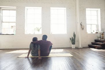 Young couple sitting on carpet in a loft