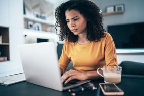 Young modern woman working from home, using laptop