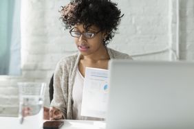 black woman looking at charts at laptop