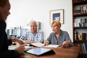 An older couple meets with a credit counselor to review their debt relief options.