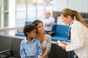 Doctor speaks with mother and young son in waiting room