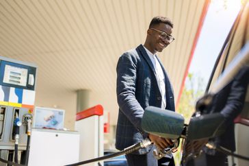 A man refuels his car at the gas station. 