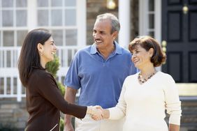 Couple shaking hands with a real estate agent