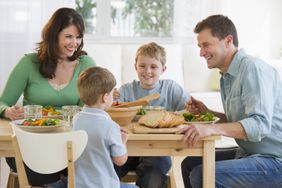 Young family smiling while sharing a meal