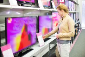 A woman checks the specs on a new TV she may purchase.