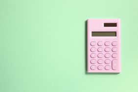 Bird's-eye view of a pink calculator on a mint green background