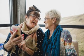 Two laughing retired women enjoy some time together.
