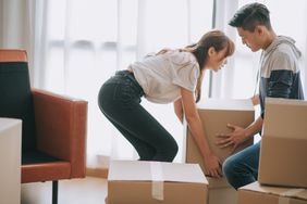 A couple moves boxes in a home or apartment
