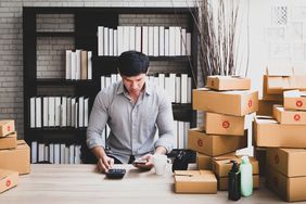 Man working at home preparing merchandise sold online in small business