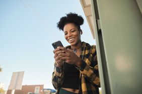 A woman looks at her phone and smiles