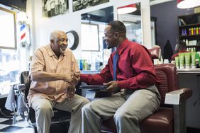 Two men shaking hands on an agreement in a barber shop