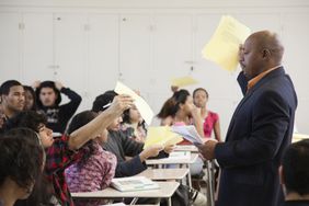 Teacher holding papers in classroom