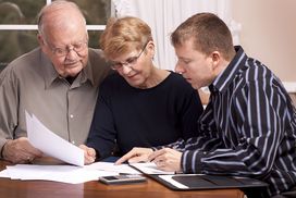 Senior couple talking to a financial advisor about inheritance tax their beneficiaries may have to pay.